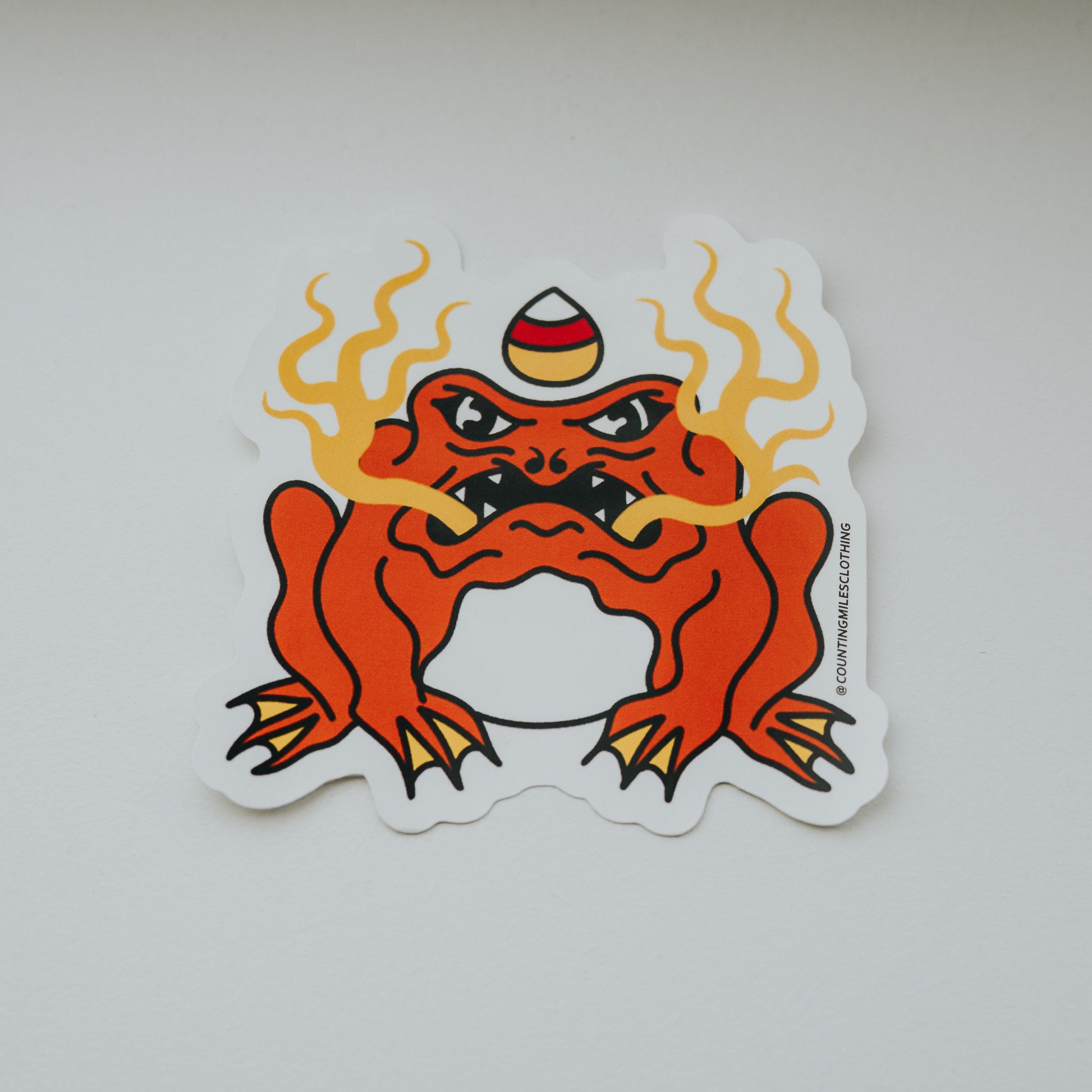 Sticker of a red creature with flames on a white surface