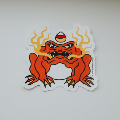 Sticker of a red creature with flames on a white surface