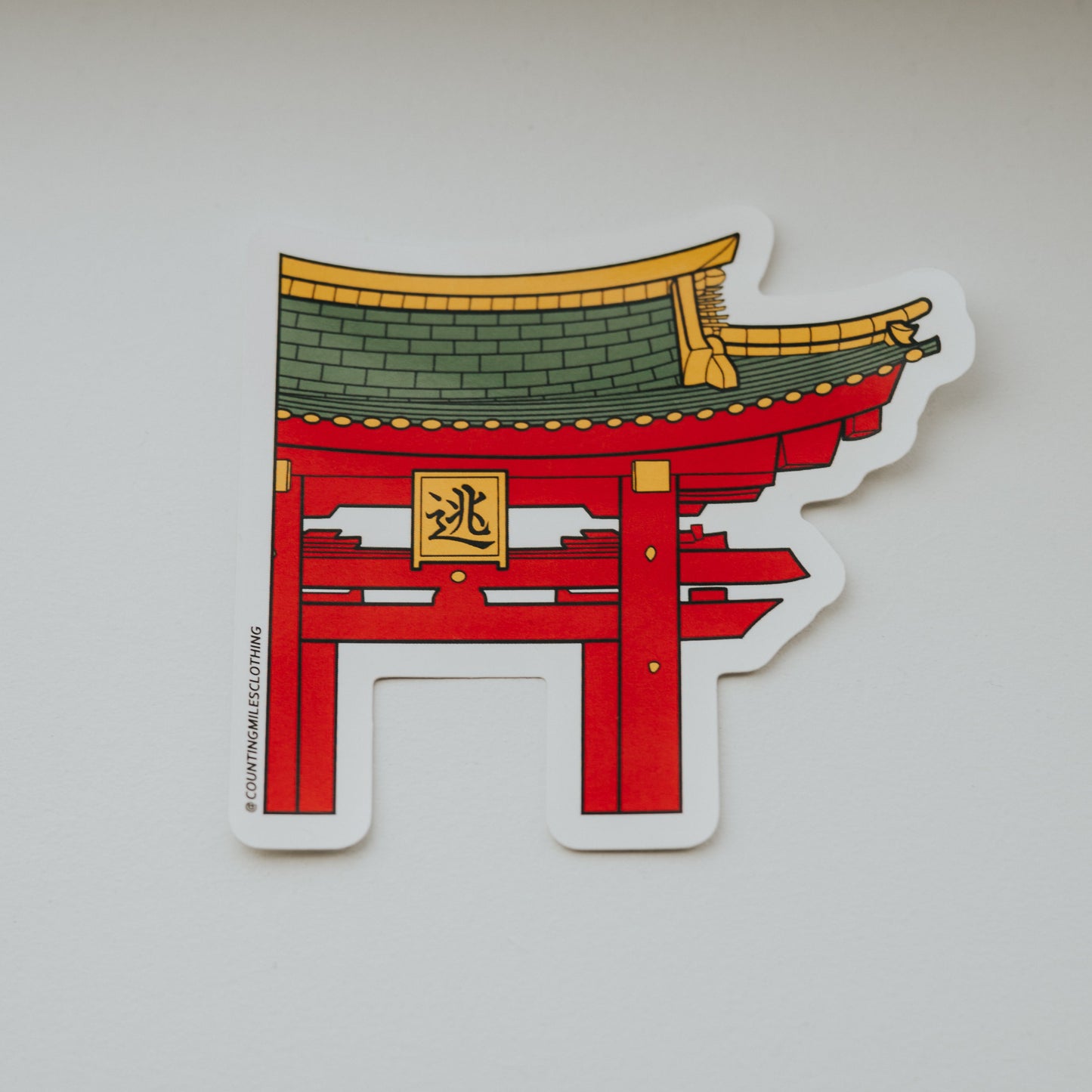 Sticker of a red and green traditional Japanese gate on a white surface